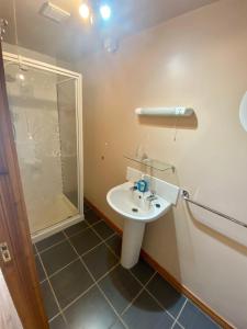a bathroom with a sink and a shower at Beachview Cottage Co. Antrim in Cushendun +31 photos