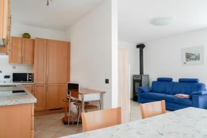 a kitchen and a living room with a blue couch at Agritur La Crucola in Flavon