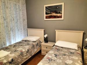 - une chambre avec 2 lits et une photo sur le mur dans l'établissement Tre Continenti - Appartamento con parcheggio privato, à Ronchi dei Legionari