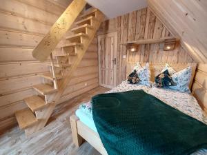 a bedroom with a bed and a wooden staircase at DOMEK Z BALA ELITA in Kościelisko