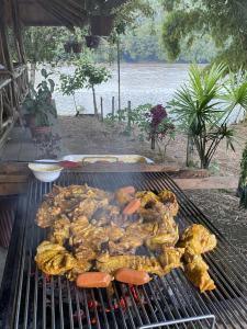 a bunch of meat and hot dogs on a grill at Playa Tortuga in Puerto Misahuallí