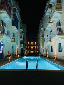 basen w środku budynku w nocy w obiekcie New, Modern Ground Floor Apartment with Pool w mieście Għajnsielem