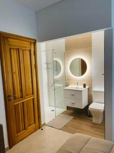 W łazience znajduje się toaleta, umywalka i prysznic. w obiekcie New, Modern Ground Floor Apartment with Pool w mieście Għajnsielem