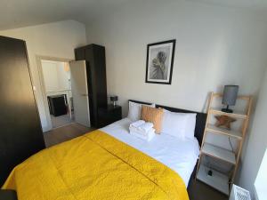 a bedroom with a bed with a yellow blanket at Marylebone Gloucester Place Apartments in London