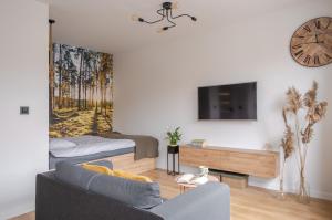 a living room with a couch and a tv on a wall at MGM HOME Wawer Międzylesie Centrum Zdrowia Dziecka in Warsaw