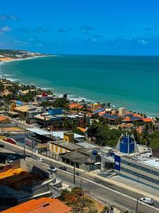 uma vista aérea de uma cidade e do oceano em Janastí Suítes Praia de Ponta Negra em Natal