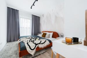 a white bedroom with a bed and a desk at Lake Club Apartments by LoftAffair in Mikołajki