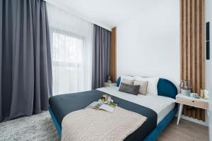 a bedroom with a large bed and a window at Lake Club Apartments by LoftAffair in Mikołajki