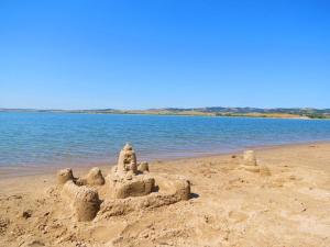 a sand castle on a beach next to the water at Angostura Oasis in Hot Springs