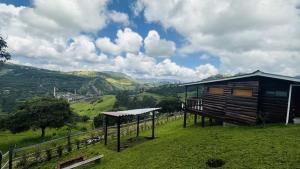 a cabin on a hill with a view of a valley at Eco Cabañas del Encanto, La Calera in La Calera