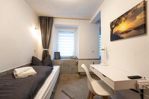 ein Hotelzimmer mit einem Bett, einem Schreibtisch und einem Schreibtisch in der Unterkunft Pension Krone in Freiberg