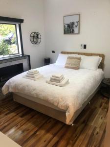 a bedroom with a bed with three towels on it at Warburton Woods point nature retreat in Warburton
