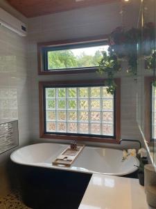 baño con bañera grande y ventana en Warburton Woods point nature retreat, en Warburton