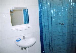 a bathroom with a sink and a blue shower curtain at Jamilasapartment in Agadir