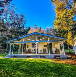 ein weißes Haus mit einer Veranda auf einem Rasen in der Unterkunft Bright, Updated Waterfront Cottage Pets Welcome! in Longview