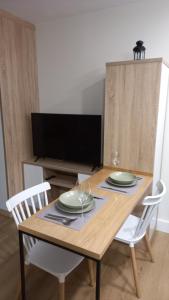 a wooden table with two chairs and a television at IRLA in Pontevedra