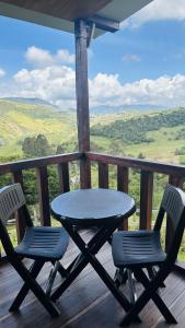 a table and chairs on a deck with a view at Eco Chalet El Encanto La Calera in La Calera