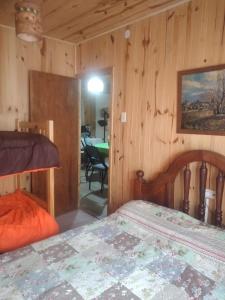 a bedroom with a bed in a room with wooden walls at Casa Azul in Potrerillos