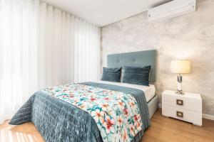een slaapkamer met een bed met een blauw dekbed bij Studio Sweet Dreams in Aveiro touristic center in Aveiro