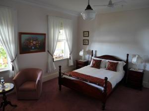 a bedroom with a bed and a chair and window at Leconfield House in Greta