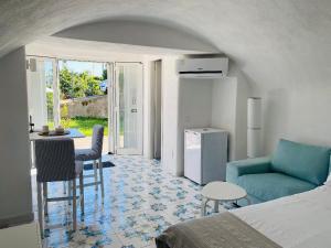 um quarto com uma cama, uma mesa e um sofá em Grazioso MONOLOCALE nella villa NOLELU em Ischia