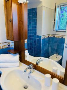 uma casa de banho com um lavatório, uma banheira e um espelho. em Grazioso MONOLOCALE nella villa NOLELU em Ischia