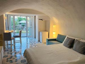 una camera con letto e un soggiorno di Grazioso MONOLOCALE nella villa NOLELU a Ischia