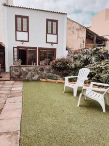 twee witte stoelen op een gazon voor een huis bij Casa La Encarnación in Santa Cruz de la Palma