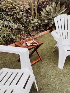 twee witte stoelen en een tafel met wijnglazen erop bij Casa La Encarnación in Santa Cruz de la Palma