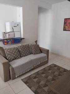 a living room with a couch with pillows on it at Agua Marinha Campos in Campos dos Goytacazes +8 photos