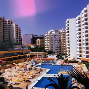 una grande piscina con ombrelloni e persone in città di MARIACAST CLUBE DA PRAIA DA ROCHA a Portimão Altre 16 foto
