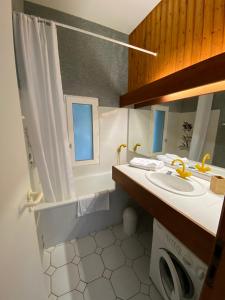 La salle de bains est pourvue d'un lavabo et d'un lave-linge. dans l'établissement Appartement vue mer île d'Oléron, à Saint-Trojan-les-Bains
