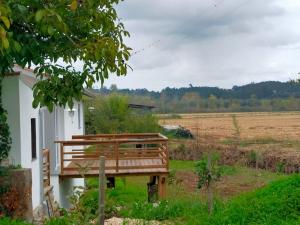 a wooden bench sitting next to a white building at CASINHA DO RIO in Soure +35 photos