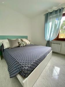 a bedroom with a bed with a blue comforter and a window at Sunrise apartament in Monterosso al Mare