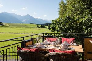 a wooden table with red napkins and chairs on a balcony at Sonnenalp Resort in Ofterschwang +52 photos