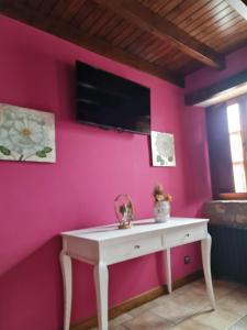 a pink wall with a white table in a room at La Torruca in Oreña