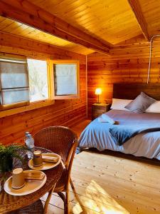1 dormitorio con 1 cama y 1 mesa en una cabaña en El Bosque de Ribera, en Escalona