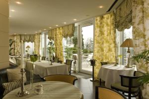 a restaurant with two tables and chairs and windows at Schlosshotel Burg Schlitz in Hohen Demzin