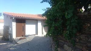 a building with a door and a stone wall at Casa da Memória in Milhão