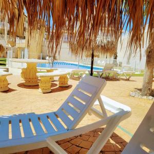 biały fotel siedzący obok basenu w obiekcie Apartamento Carlos , Lomas de Cabo Roig area, self check-in, You don't need to wait for the keys,2 bedroom,2 terraces,swimming pool w mieście Orihuela Costa