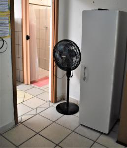 un ventilador sentado en un baño junto a una puerta en Kitnet Itapema, en Itapema