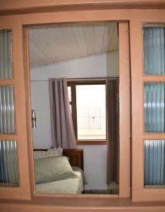 1 dormitorio con ventana y 1 cama. en Kitnet Itapema, en Itapema