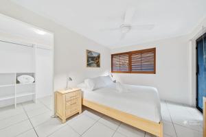 Un dormitorio blanco con una cama y una ventana. en Mooloomba One by Discover Stradbroke, en Point Lookout