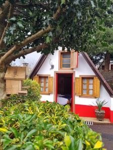 una casa rossa e bianca con una porta rossa di Abrigo da Serra- Nature Trails a Santana