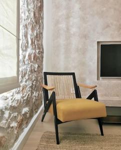 a chair with a yellow cushion in a living room at Apartman Noa in Široki Brijeg