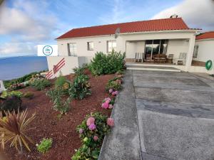 une maison avec l'océan en arrière-plan dans l'établissement Casa da Vigia, à Calheta de Nesquim