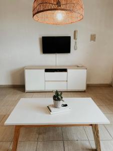 sala de estar con mesa de centro blanca y TV en Departamento Nórdico en Posadas