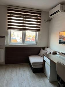 ein kleines Zimmer mit einem Sofa und einem Fenster in der Unterkunft Deni Apartments in Prilep