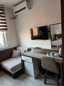 um quarto com uma secretária, um sofá e uma televisão em Deni Apartments em Prilepo