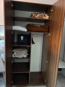 a closet with a wooden cabinet with towels at Deni Apartments in Prilep